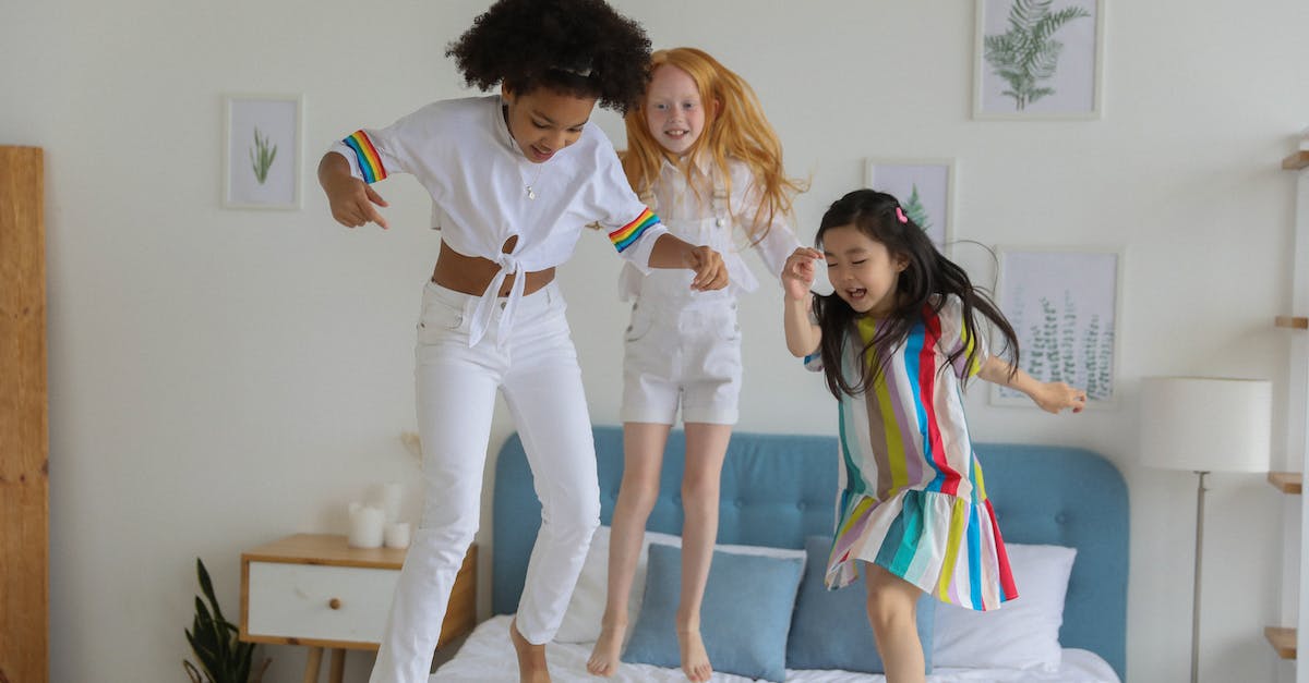 Best move when they are no more certain moves left - Happy diverse girls in casual outfit jumping on bed
