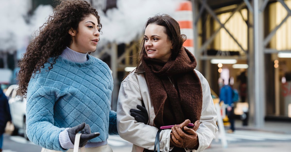 Best way to utilize cake - Positive stylish multiethnic women talking and crossing road in city Best way to utilize cake - Positive stylish multiethnic women talking and crossing road in city