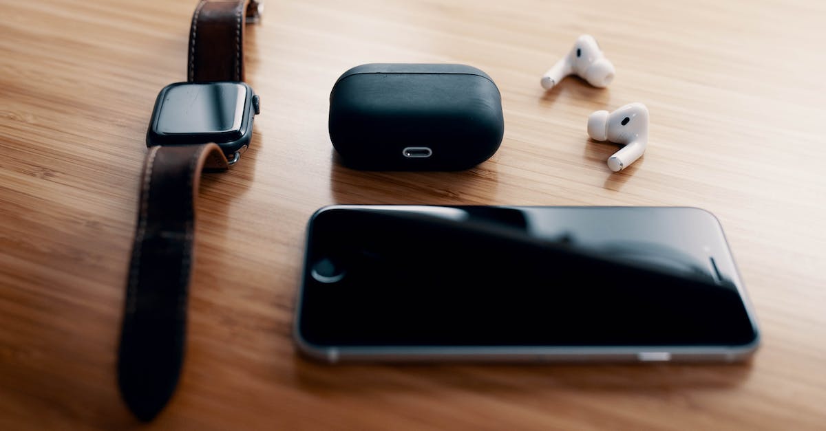 Black screen after login, but sound can still be heard on title screen - Black smart watch and TWS earbuds with charging case and smartphone lying on wooden table