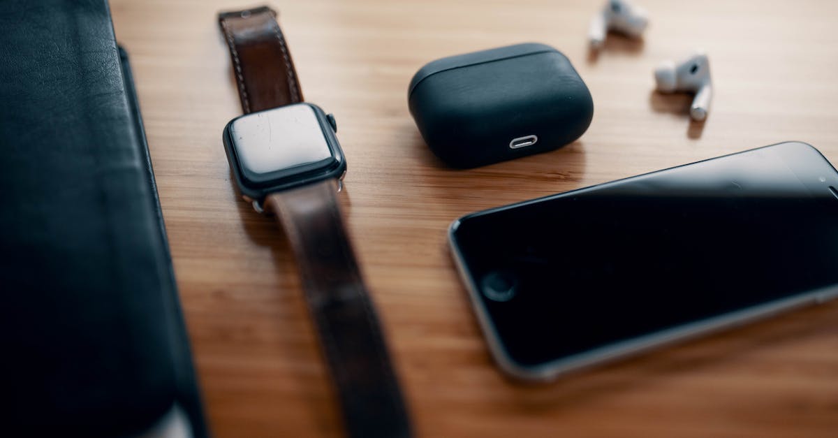 Black screen after login, but sound can still be heard on title screen - Black smart watch on leather strap and earbuds with charging case and smartphone near black notebook on wooden table