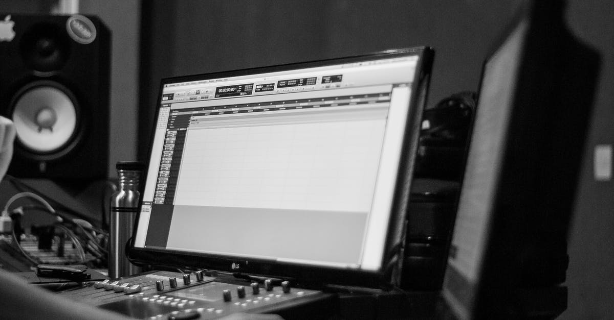 Black screen after login, but sound can still be heard on title screen - Black and white of crop anonymous sound technician using music software on computer with mixing console against speaker