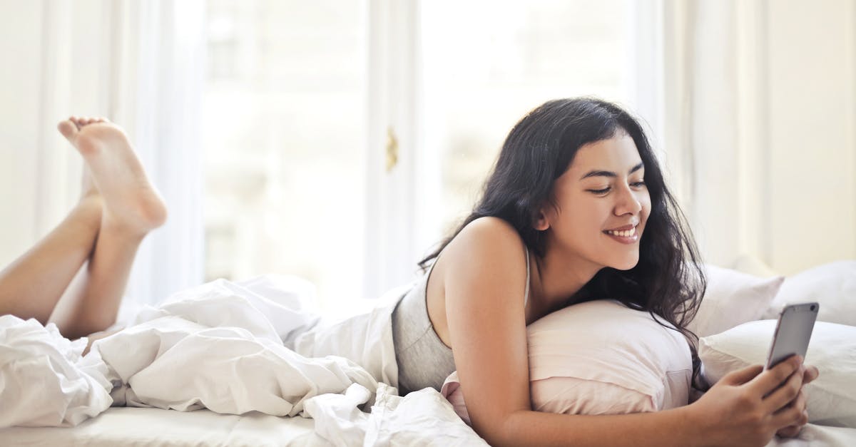 Blissey Base Daylight saving time - Happy young woman browsing phone on bed
