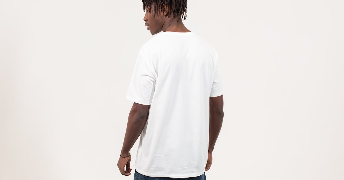 Bloodskal Barrow won't appear - Back view of serious young African American guy with dreadlocks in casual t shirt standing against white background and looking away