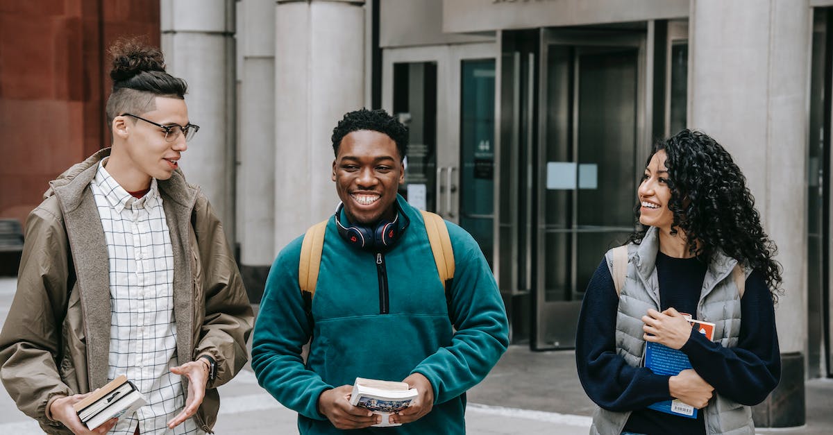 Book 2: How do I get Abby to talk to me in Chapter 4: Dreaming? - Group of smiling multiracial students with books strolling near building