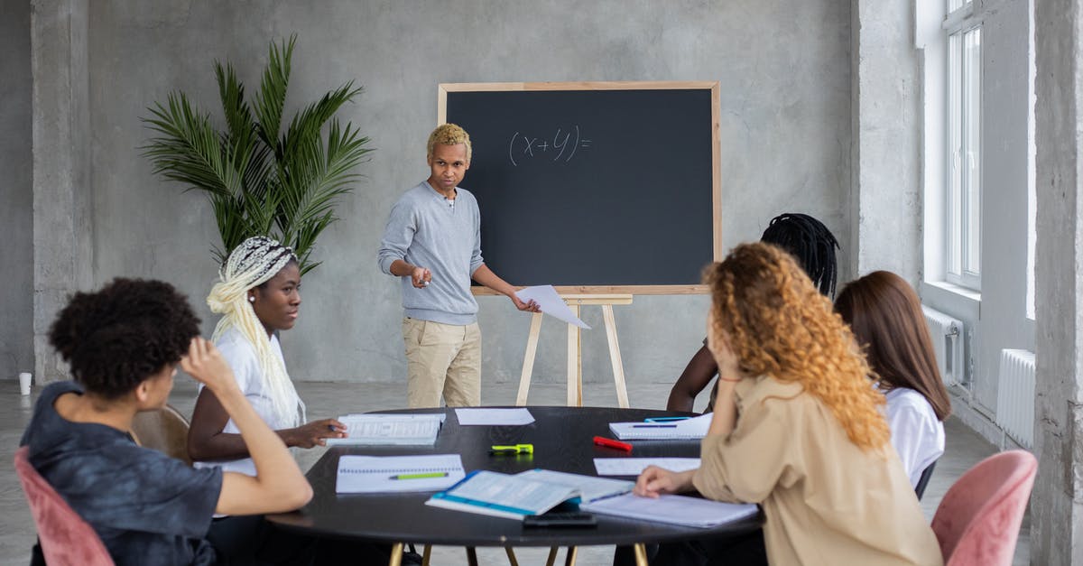 Book 2: How do I get Abby to talk to me in Chapter 4: Dreaming? - African American student explaining mathematic equation to diverse classmates while doing homework together in spacious room