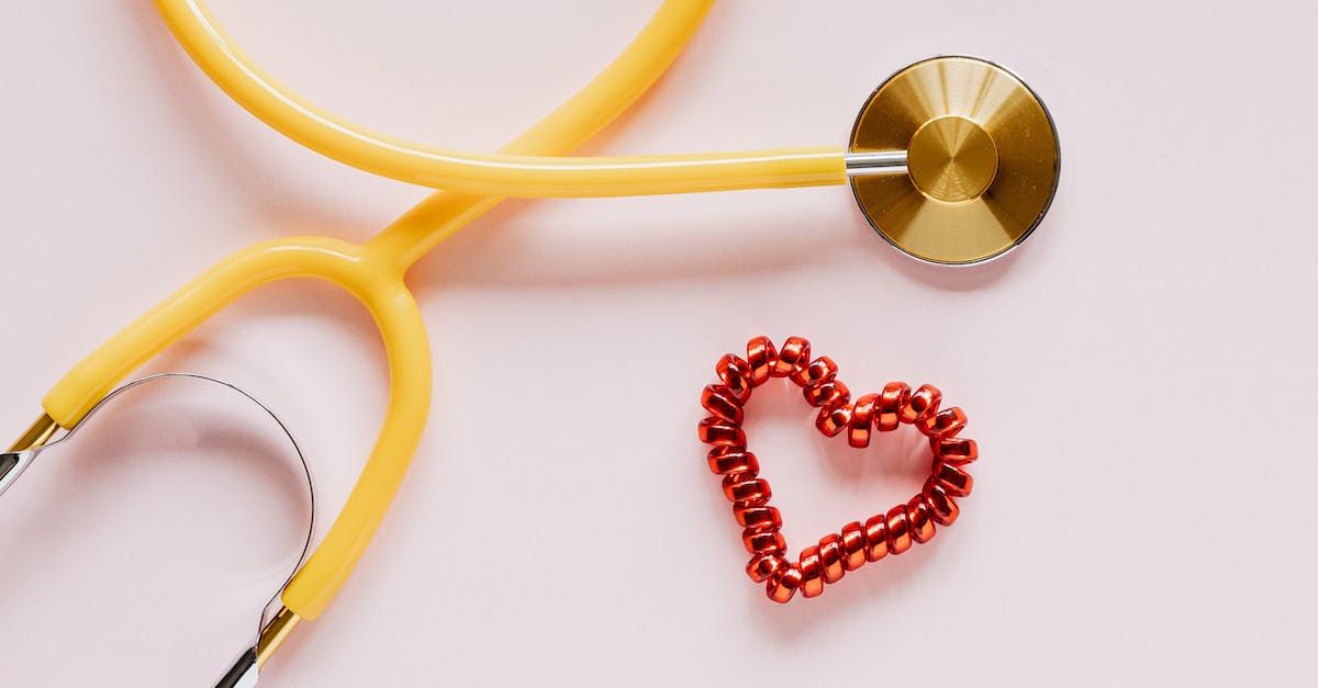 Borgakh the Steel Heart not following after marriage - Stethoscope near decorative coil tie in heart shape on pink surface