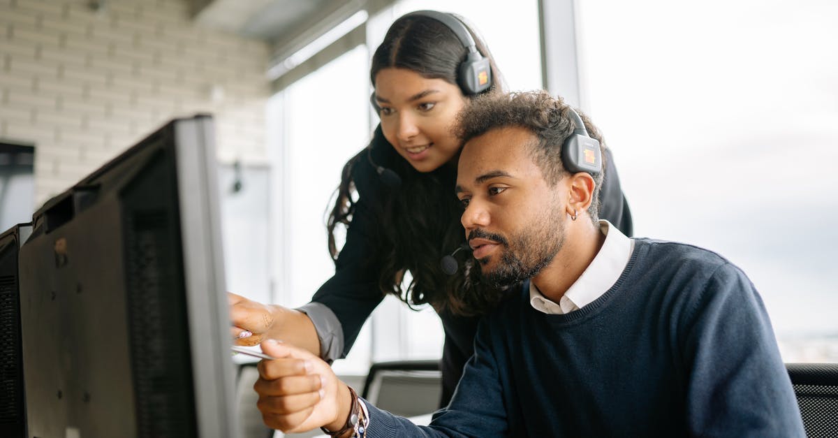 Brainwashed or sleeper agents - A Man and a Woman Pointing at the Computer Screen Brainwashed or sleeper agents - A Man and a Woman Pointing at the Computer Screen