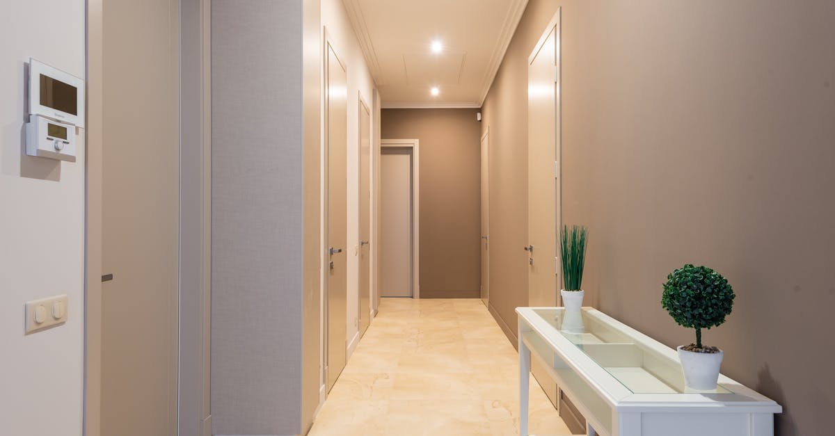 Building utilities on a wall corner - Spacious hallway with gray doors