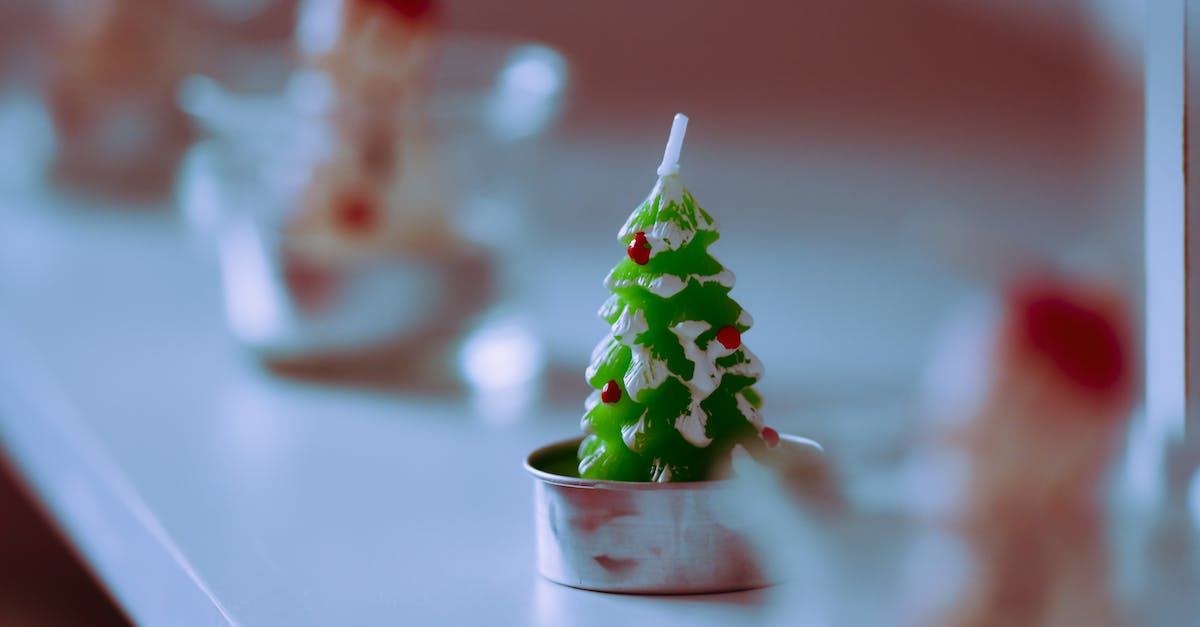 Buyers in Eve Regional Market - Christmas tree shaped candle placed on shelf in shop Buyers in Eve Regional Market - Christmas tree shaped candle placed on shelf in shop