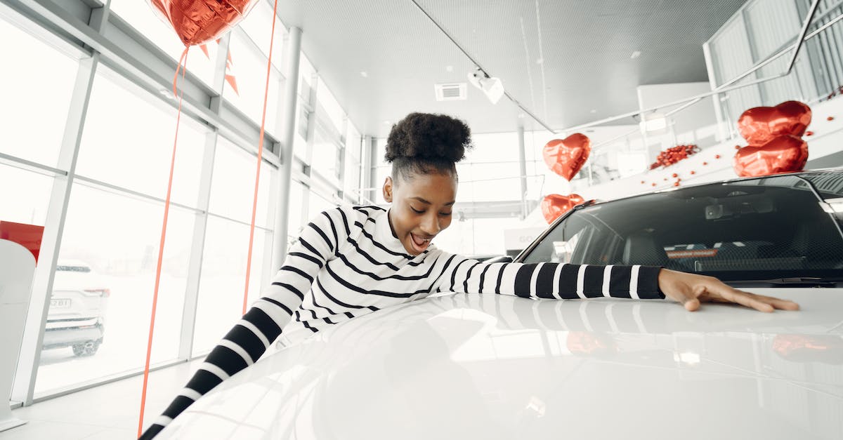 Buying Grenth's hood? - Young Woman Touching a New Car at Car Dealership