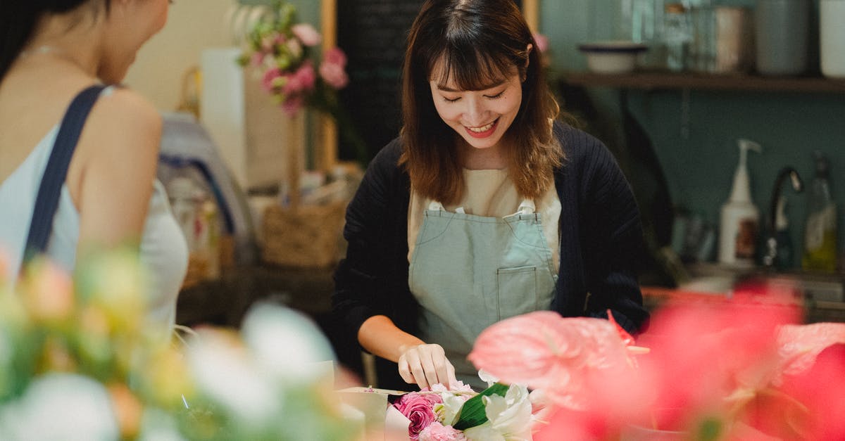 Buying Premium Pass in Just Dace 2017 also works for 2018 edition? - Content Asian female florist wearing light green apron composing tender bouquet for positive female customer while working at counter in floristry shop Buying Premium Pass in Just Dace 2017 also works for 2018 edition? - Content Asian female florist wearing light green apron composing tender bouquet for positive female customer while working at counter in floristry shop