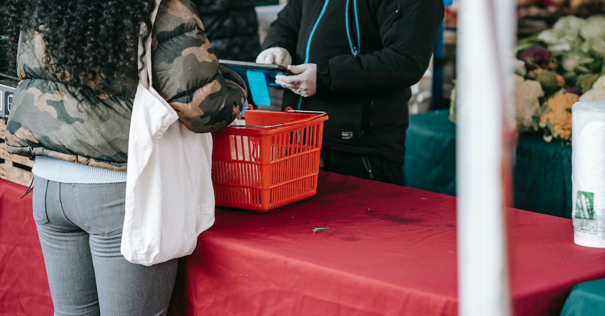 Calculating Hero Cost to buy up to a certain level - Customer and seller in protective gloves in food market Calculating Hero Cost to buy up to a certain level - Customer and seller in protective gloves in food market