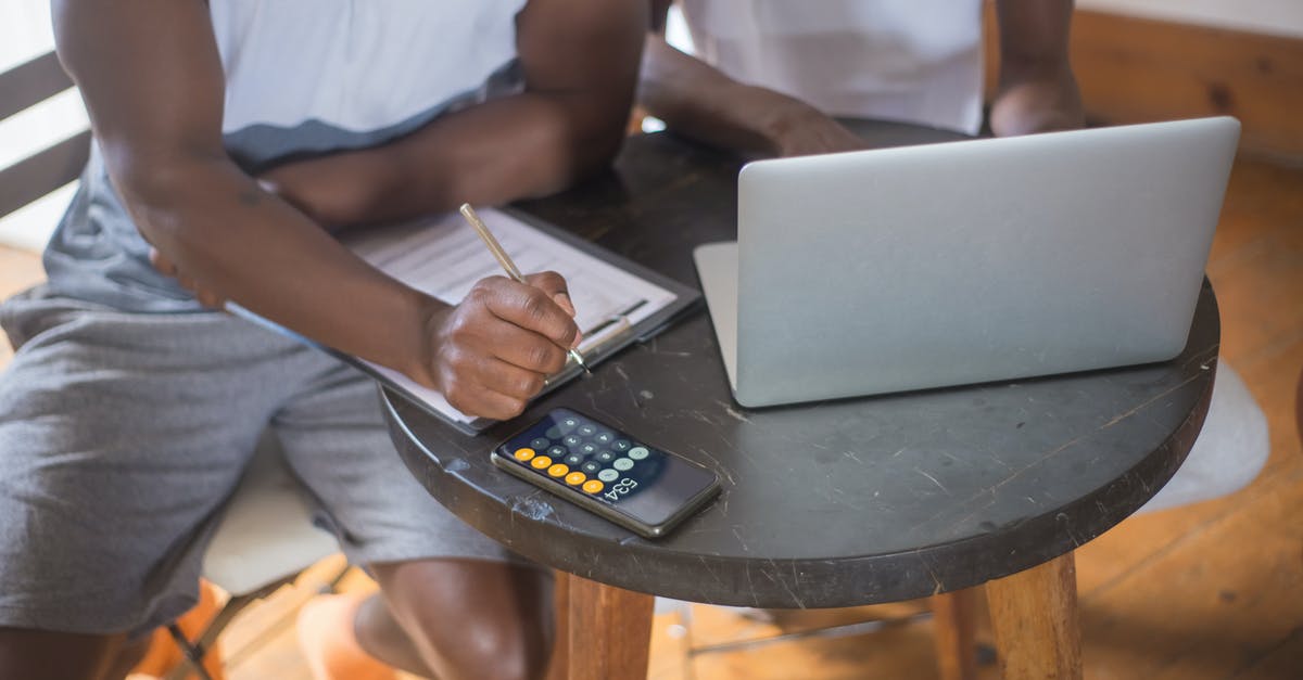 Calculating Pokémon IVs in Pokémon GO - Two People in White T-shirts Using Laptop and Calculator