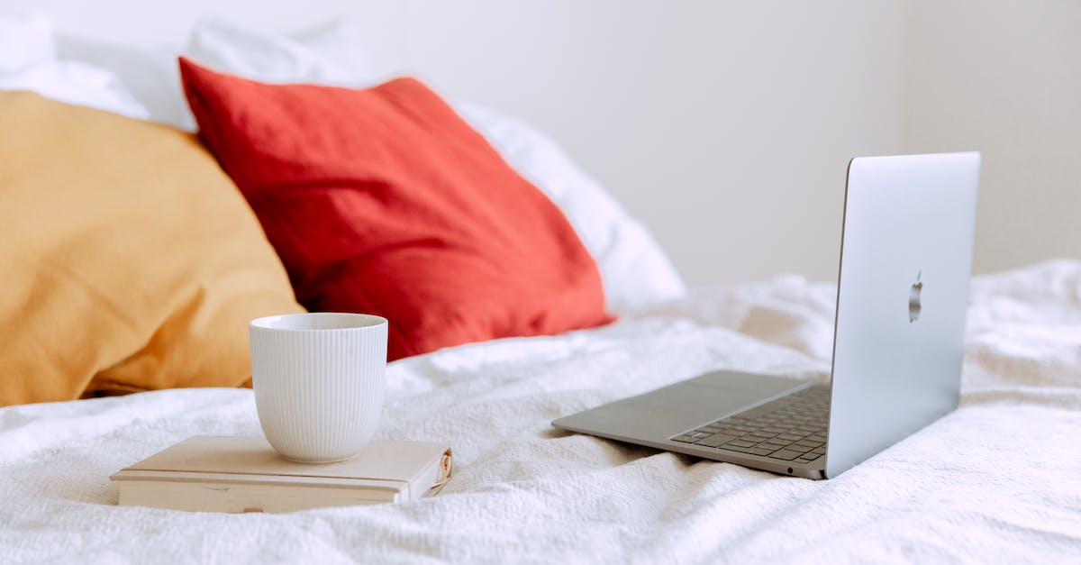 Can't connect to Facebook? - Laptop and cup of coffee on notepad near pillows on bed at daytime