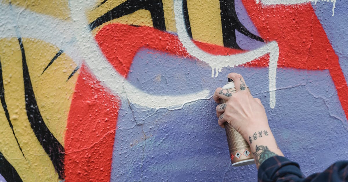 Can't Create Riot Account - Hand of crop anonymous tattooed person spraying white paint from can on colorful wall while standing on street of city Can't Create Riot Account - Hand of crop anonymous tattooed person spraying white paint from can on colorful wall while standing on street of city