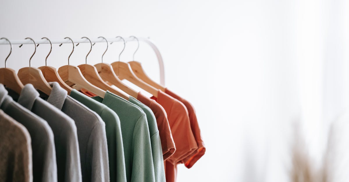 Can't find new DLC Not A Hero - Interior of light apartment with different clothes on wooden hangers in wardrobe near white walls