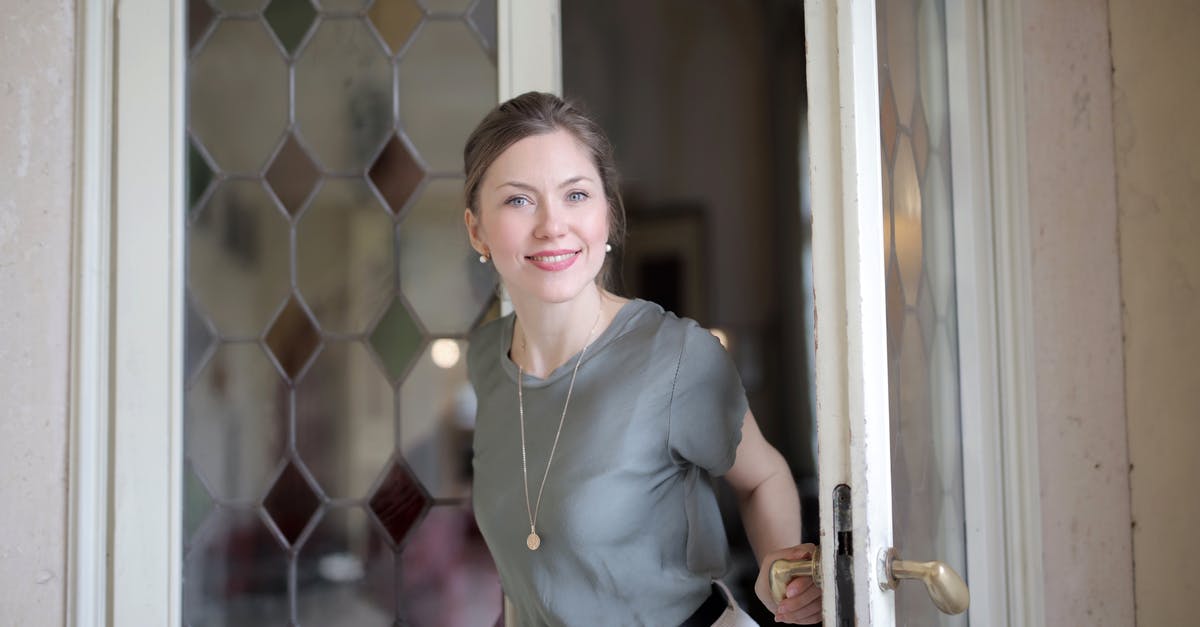 Can't finish building my house - Young smiling female in casual outfit looking at camera and holding on doorknob while entering through stained glass vintage door in ancient building Can't finish building my house - Young smiling female in casual outfit looking at camera and holding on doorknob while entering through stained glass vintage door in ancient building