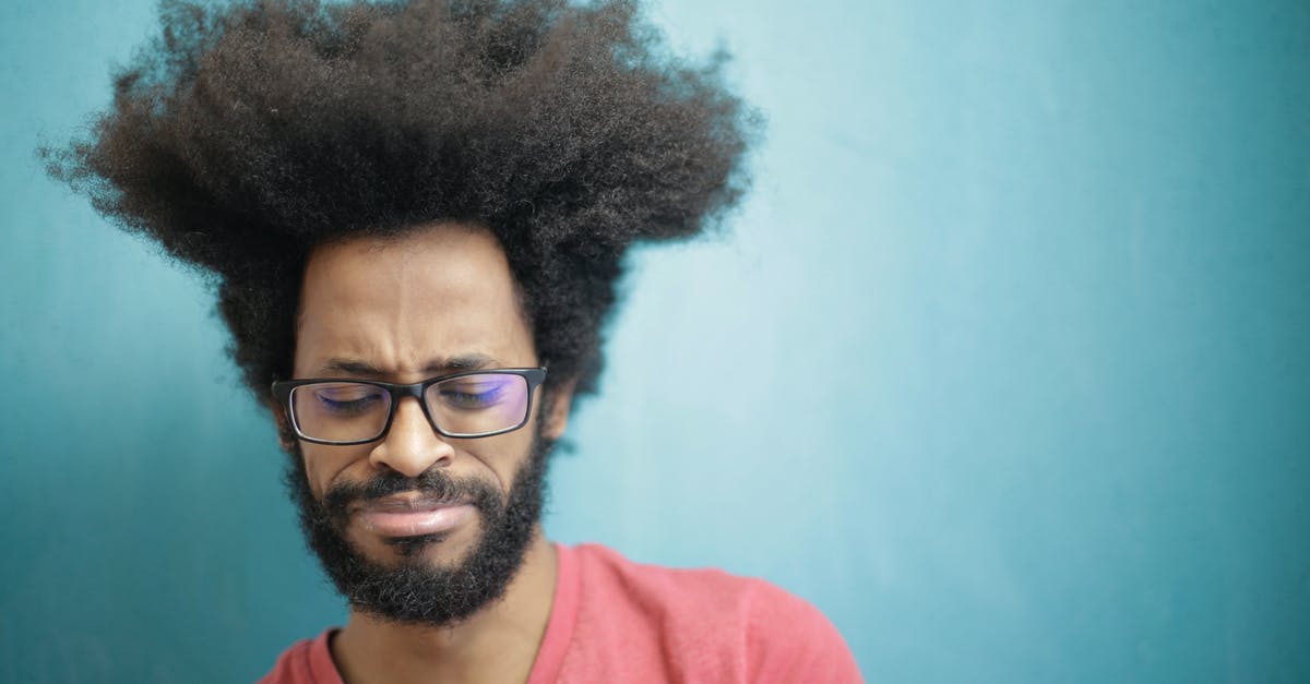 Can't get into 3rd puzzle - Young bearded ethnic male with creative Afro hairstyle wearing eyeglasses and pink t shirt looking down pensively thinking about trouble or question Can't get into 3rd puzzle - Young bearded ethnic male with creative Afro hairstyle wearing eyeglasses and pink t shirt looking down pensively thinking about trouble or question