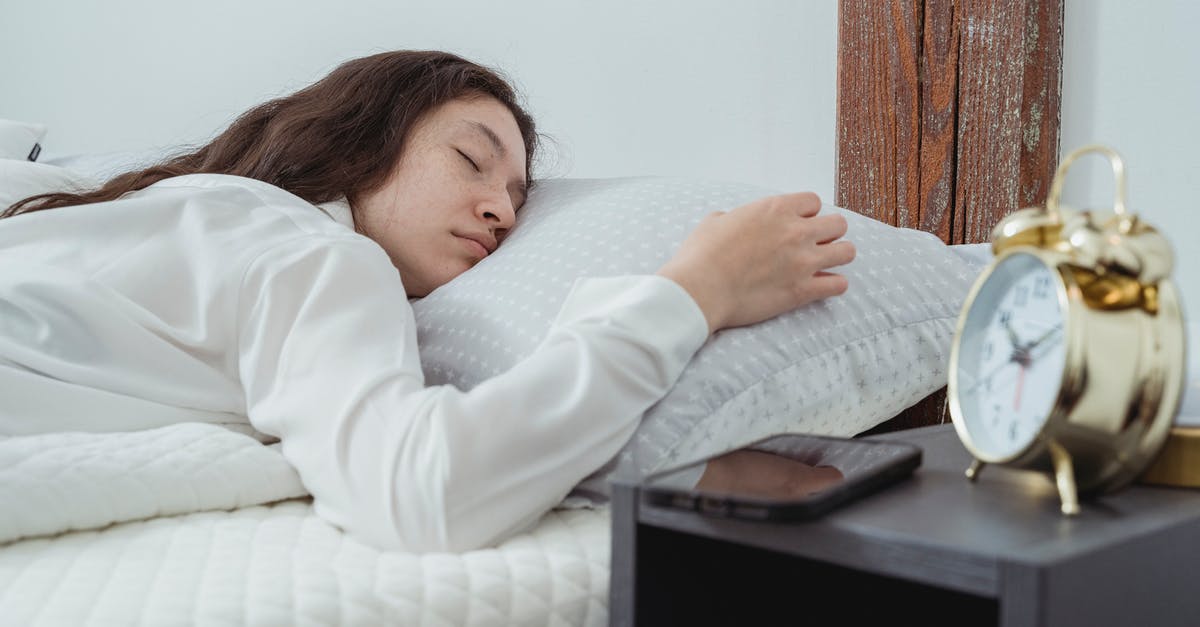 Can't long-press ALT or CTRL, only once at a time [closed] - Young woman with dark long wavy hair sleeping peacefully on belly on comfortable bed under white blanket near bedside table with alarm clock and smartphone