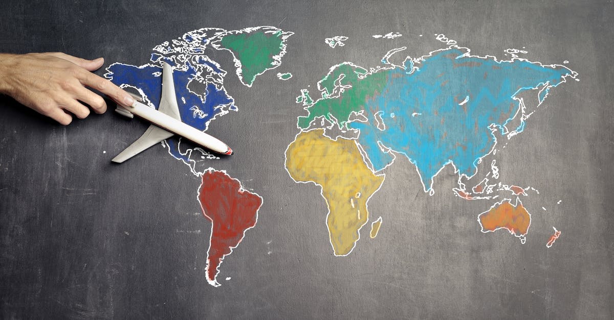 Can't rename world after adding "color" - Top view of crop anonymous person holding toy airplane on colorful world map drawn on chalkboard