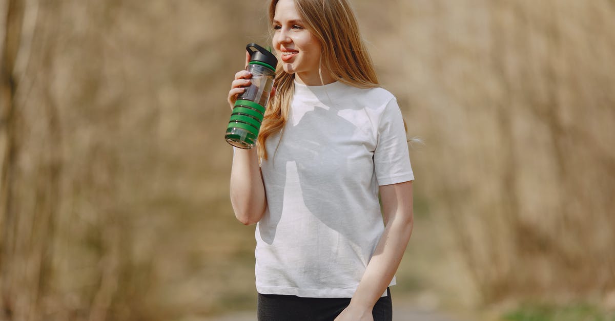 Can't run any program in - Smiling woman drinking water during training in park Can't run any program in - Smiling woman drinking water during training in park