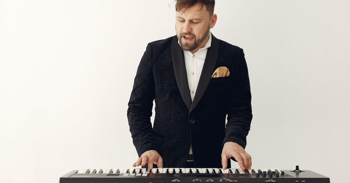 Can an Xbox One player party or voice chat with an Xbox 360 player? - Stylish adult bearded man singing and playing synthesizer