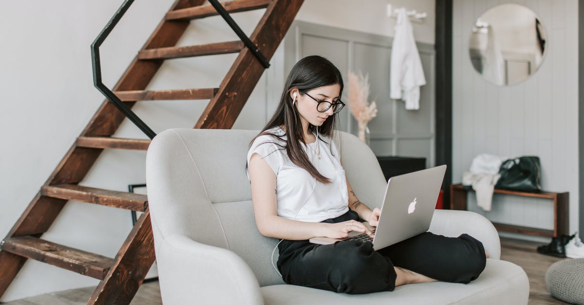 Can Civ V support internet multiplayer with casual log-out/log-in? - Young female in eyeglasses and casual clothes sitting barefoot on sofa in modern apartment with wooden staircase while wearing earbuds and watching movie on netbook