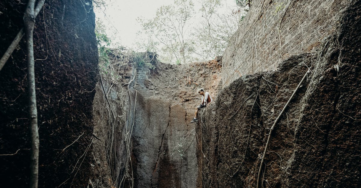 Can endermen teleport up a hill with overhanging edge - Person in White Shirt Climbing on Brown Rocky Mountain
