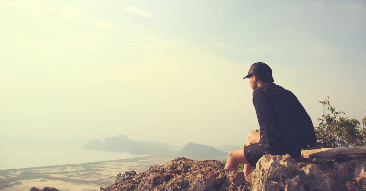 Can endermen teleport up a hill with overhanging edge - Man Sitting on Brown Rocks Facing Seashore