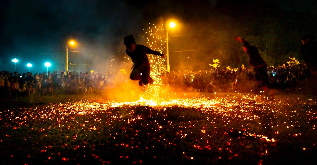 Can Falco shine Fire Fox? - Active people jumping in hot burning sparks of fire among crowd of people at night Can Falco shine Fire Fox? - Active people jumping in hot burning sparks of fire among crowd of people at night