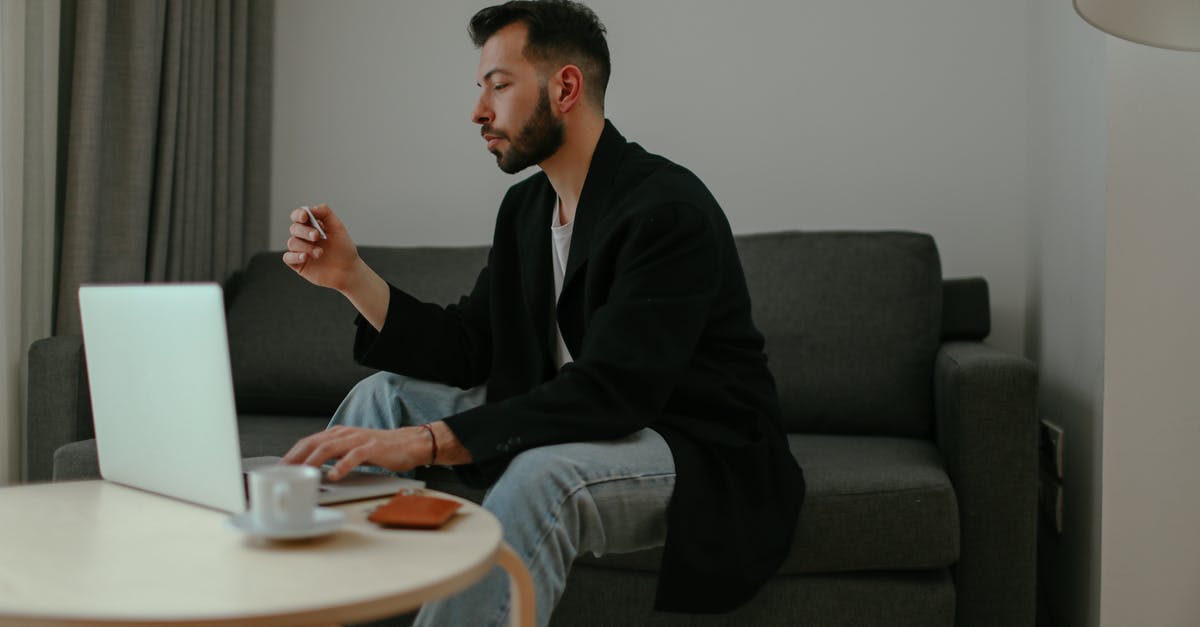 Can Genji deflect when using Dragonblade? - Man in Black Blazer and Denim Pants Sitting on a Couch while Using a Laptop