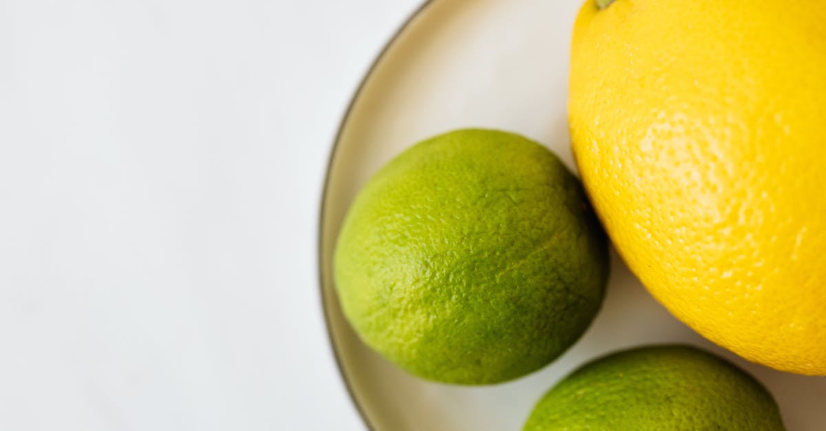 Can Green Set Items be picked up by other players? - Top view of closeup whole ripe lemon and limes served on white metal plate on white surface