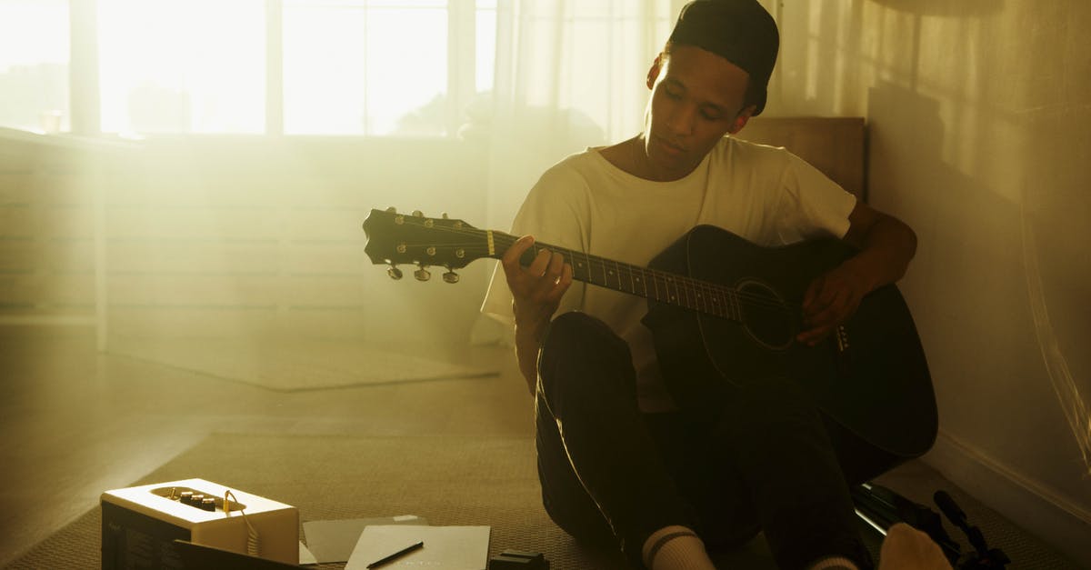 Can Guitar Hero Warriors of Rock (PS3) peripherals work with Rock Band 4 (PS4)? - Man in White Crew Neck T-shirt Playing Acoustic Guitar