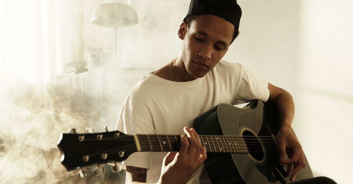 Can Guitar Hero Warriors of Rock (PS3) peripherals work with Rock Band 4 (PS4)? - Man in White Crew Neck T-shirt Playing Acoustic Guitar