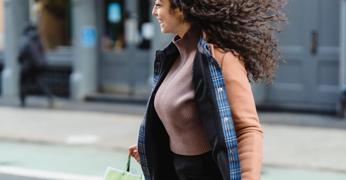 Can I catch Pokémon when I move very quickly? - Positive young ethnic female with flowing hair carrying shopping paper bags while quickly crossing road and looking away Can I catch Pokémon when I move very quickly? - Positive young ethnic female with flowing hair carrying shopping paper bags while quickly crossing road and looking away