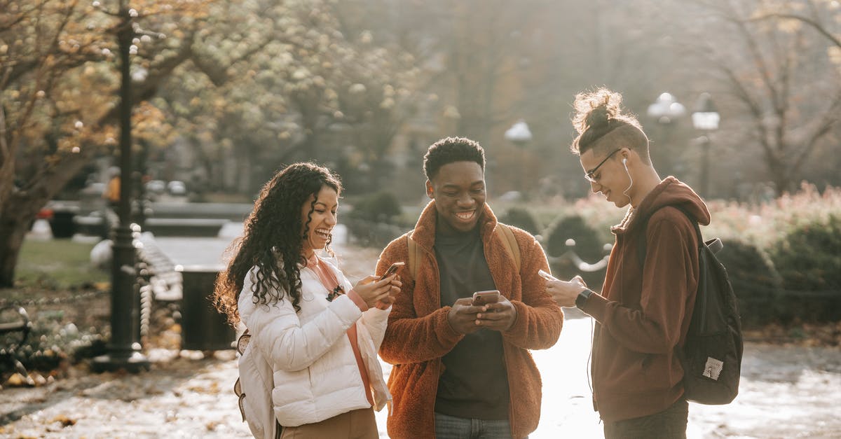 Can I clear chat using a command block? - Multiracial positive male and female students using smartphones in city park Can I clear chat using a command block? - Multiracial positive male and female students using smartphones in city park