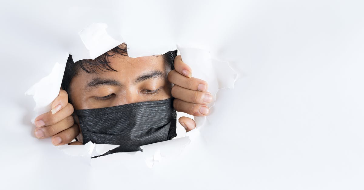 Can I hide new user's Donald medal? - Crop anonymous ethnic male in face mask looking down behind ragged paper wall during COVID 19 pandemic Can I hide new user's Donald medal? - Crop anonymous ethnic male in face mask looking down behind ragged paper wall during COVID 19 pandemic