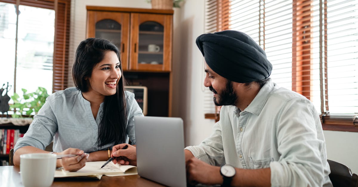 Can I import Pokémon from my Let's Go team into Pokémon Home without the original game? - Laughing Indian woman with husband sitting at table and discussing project while working together with laptop and notebook at home