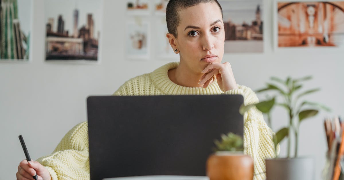 Can I install PS3 games on an external hard drive? - Serious female with short hair looking at camera while drawing with stylus at table with netbook and small potted plants