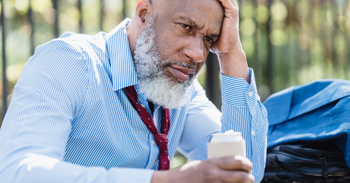 Can I jaywalk without getting into trouble? - Sad black businessman with alcohol drink on street