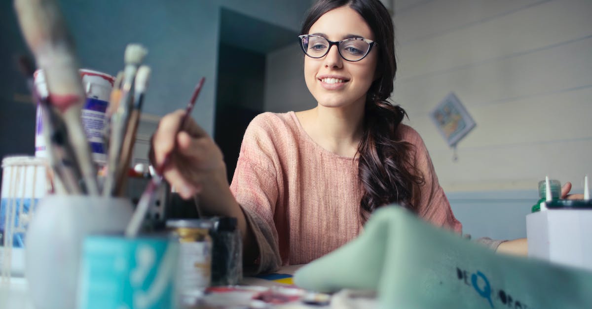 Can I Marry more than 1 girl? - Woman in Brown Long-sleeved Shirt Wearing Eyeglasses Holding Paint Brush