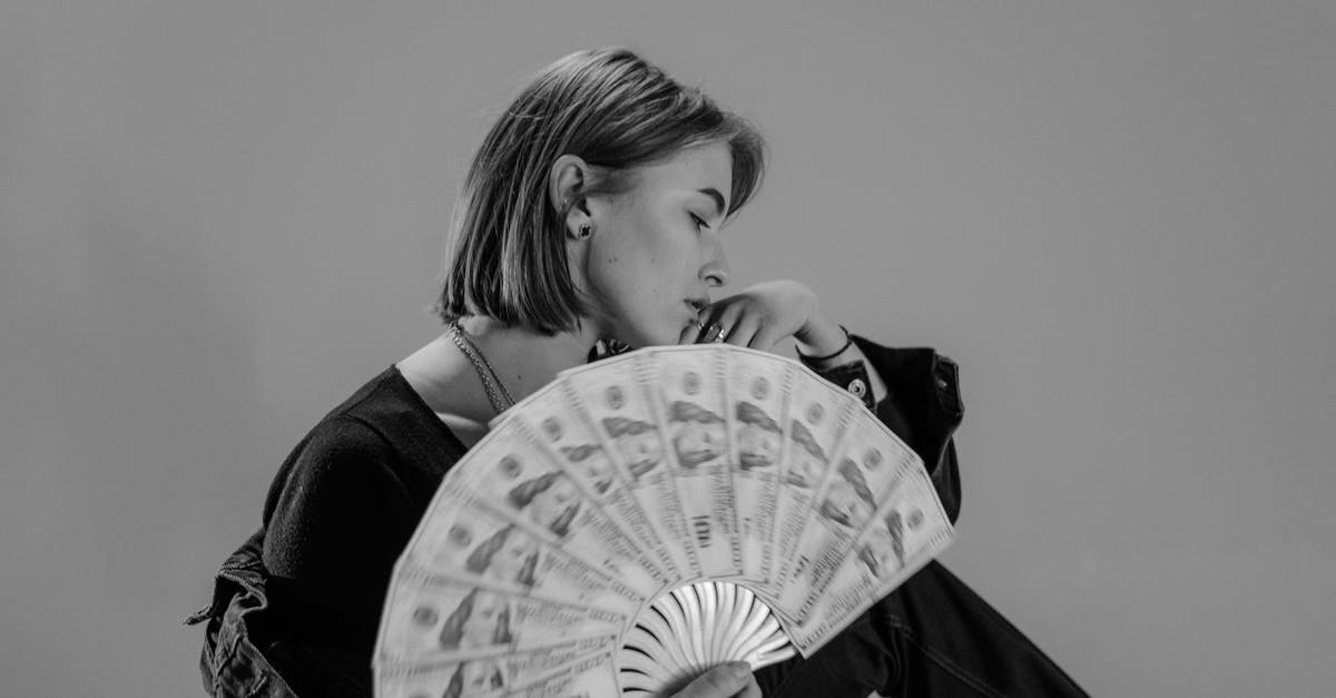 Can I obtain real money with Black Squad boxes? - Woman Holding Hand Fan Made of Paper Money