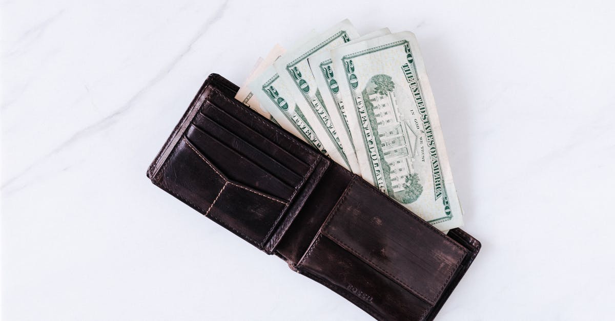 Can I obtain real money with Black Squad boxes? - From above of black leather wallet with pockets filled with heap of dollar banknotes on white table