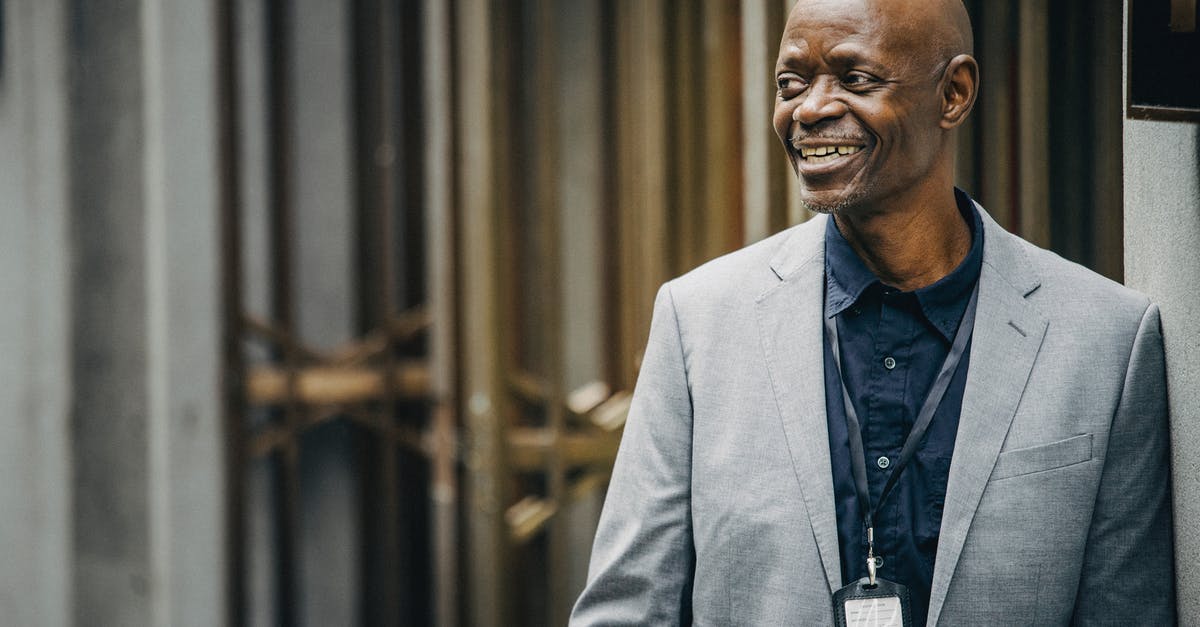 Can I pass the CEO title to someone else? - Cheerful black manager in suit looking away
