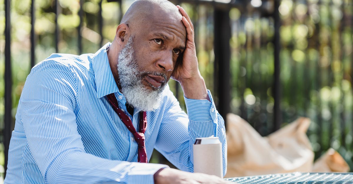 Can I pass the CEO title to someone else? - Thoughtful African American man sitting at table with tin can