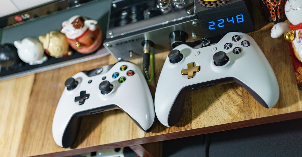 Can I play an Xbox One Fifa 17 on an Xbox 360 too? - White Xbox One Controllers on Table