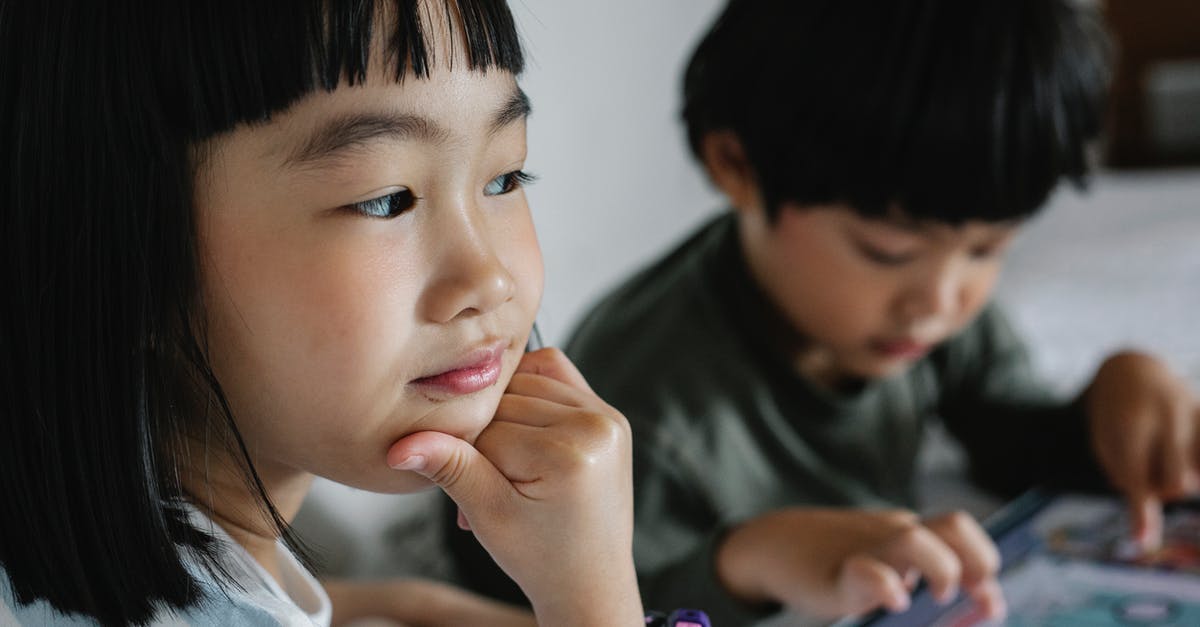 Can I play Diablo 3 online on a PS4 with my brother on the same console? - Crop concentrated ethnic girl touching chin while sitting near sibling playing game in modern device Can I play Diablo 3 online on a PS4 with my brother on the same console? - Crop concentrated ethnic girl touching chin while sitting near sibling playing game in modern device