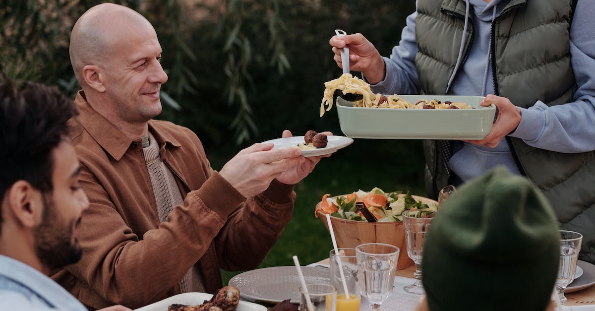 Can I put my party in a line automatically? - Unrecognizable woman serving delicious pasta with meatballs to man during dinner