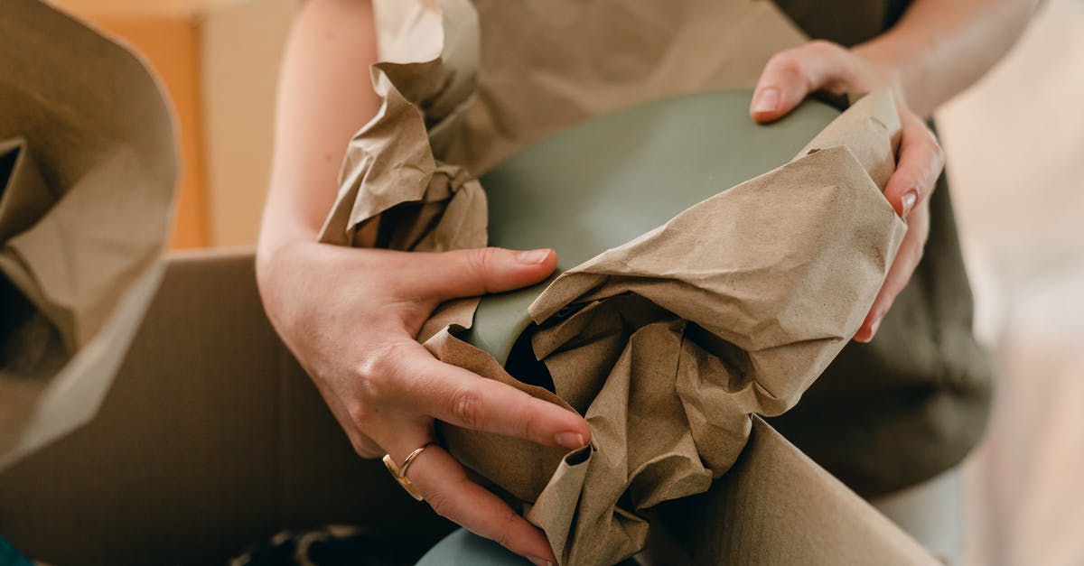 Can I put stuff from inventory into my rented storage container in my house? - Crop woman with packing paper and belongings