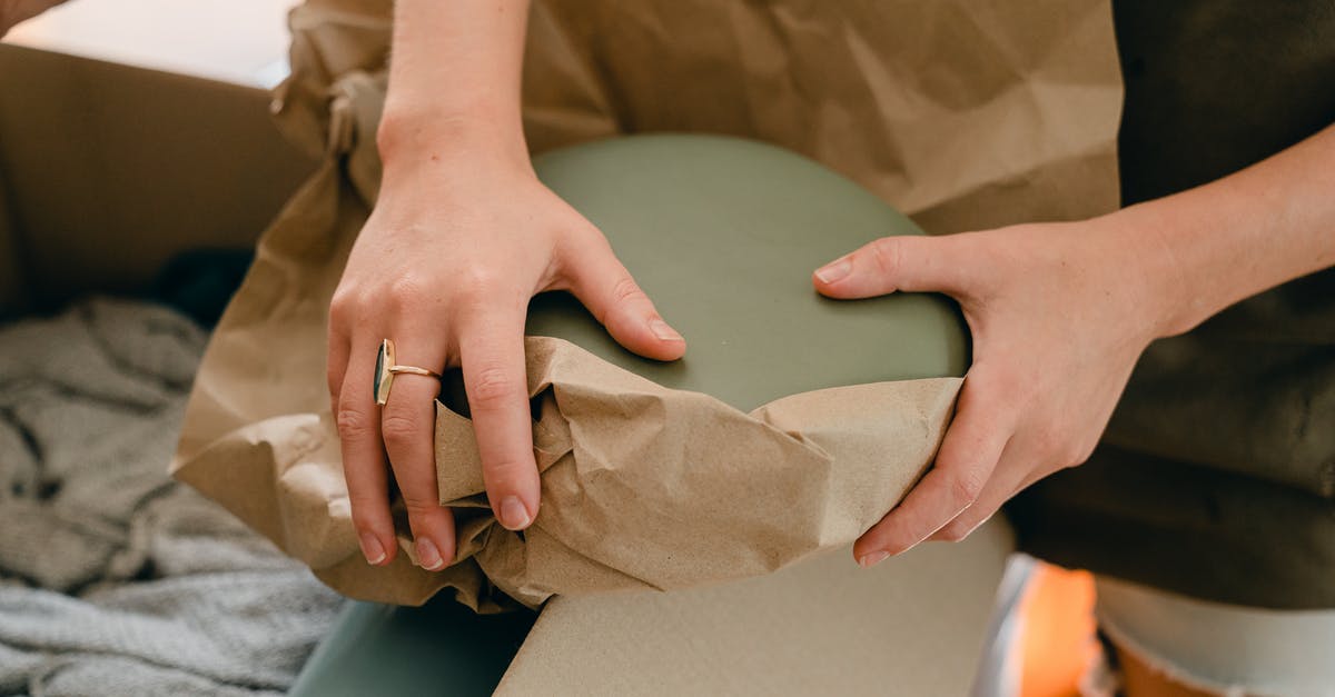 Can I put stuff from inventory into my rented storage container in my house? - Crop young woman packing fragile goods for transportation